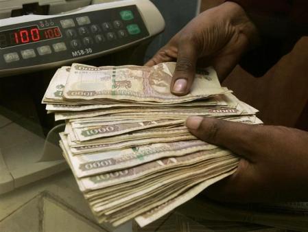 A currency dealer counts Kenya shillings at a money exchange counter in Nairobi October 23, 2008.    REUTERS/Antony Njuguna