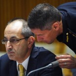 Michael Pezzullo (L), Secretary of the department of immigration and border protection, is spoken to by a department officer during his appearance at an Australian Senate Estimates Committee in Parliament House, Canberra, February 8, 2016.  REUTERS/Mick Tsikas/AAP
