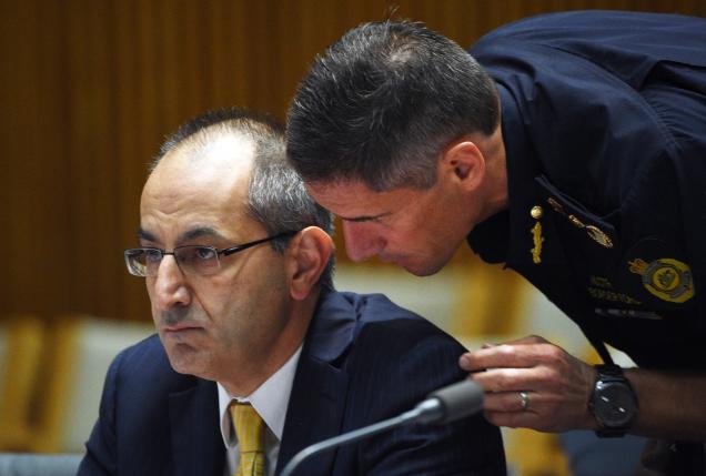 Michael Pezzullo (L), Secretary of the department of immigration and border protection, is spoken to by a department officer during his appearance at an Australian Senate Estimates Committee in Parliament House, Canberra, February 8, 2016.  REUTERS/Mick Tsikas/AAP