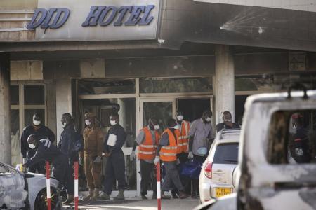 Emergency workers remove a corpse in a body bag from the Splendid Hotel in Ouagadougou, Burkina Faso, January 16, 2016, after security forces retook the hotel from al Qaeda fighters who seized it in an assault that killed two dozen people from at least 18 countries and marked a major escalation of Islamist militancy in West Africa.  REUTERS/Joe Penney