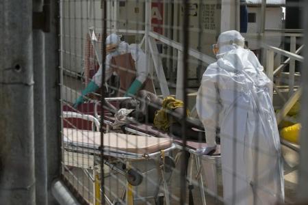 Health workers push a wheeled stretcher holding a newly admitted Ebola patient in a file photo. REUTERS/Baz Ratner