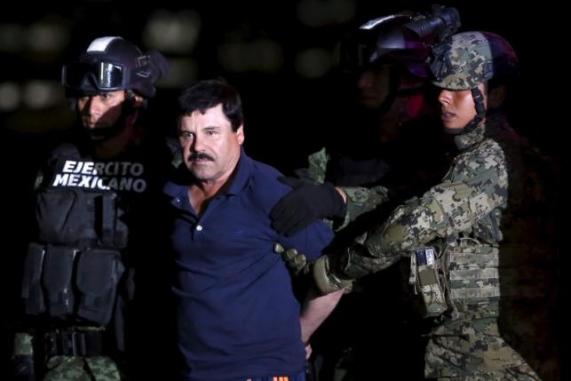 Joaquin "El Chapo" Guzman is escorted by soldiers during a presentation at the hangar belonging to the office of the Attorney General in Mexico City, Mexico January 8, 2016.  REUTERS/Edgard Garrido