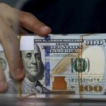 An employee of a money changer holds a stack of U.S.  Dollar notes before giving it to a customer in Jakarta, October 8, 2015   REUTERS/Beawiharta