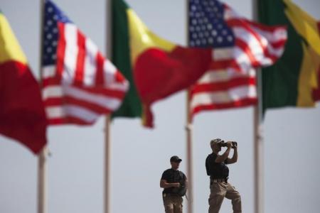 American security officers scan the airport from a rooftop below Senegalese and American flags before the departure of U.S. President Barack Obama in Dakar, Senegal, June 28, 2013.  REUTERS/Joe Penney