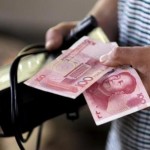 A customer holds a 100 Yuan note at a market in Beijing, August 12, 2015. REUTERS/Jason Lee