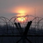 The sun sets behind a barbed wire fence near the demilitarized zone separating the two Koreas in Paju, South Korea, January 6, 2016. REUTERS/Kim Hong-Ji