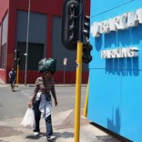 A women carries her belongings on her head as she walks past a Barclays logo in Johannesburg December 16, 2015. REUTERS/Siphiwe Sibeko