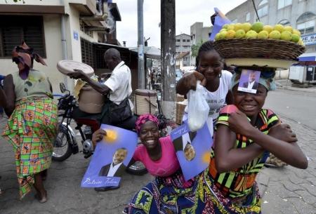 Street vendors hold campaign posters for presidential candidate Patrice Talon ahead of the second round of Benin's presidential election on Sunday in Cotonou, Benin, March 18, 2016. REUTERS/Charles Placide Tossou