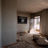 An Islamic State flag hangs on the wall of an abandoned building in Tel Hamis in Hasaka countryside after the Kurdish People's Protection Units (YPG) took control of the area March 1, 2015.  REUTERS/Rodi Said