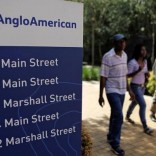 People walk past a board outside the Anglo American offices in Johannesburg January 8, 2013. REUTERS/Siphiwe Sibeko
