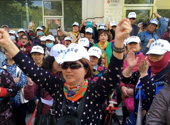 Petitioners are seen outside the National Health and Family Planning Commission of China, in Beijing, China, April 18, 2016. Chinese characters on their hats read "Parents who lost their only child". REUTERS/Kim Kyung-Hoon