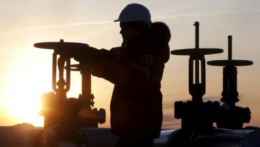 A worker checks the valve of an oil pipe at the Lukoil company owned Imilorskoye oil field outside the West Siberian city of Kogalym, Russia, January 25, 2016. Russia said on Thursday that OPEC kingpin Saudi Arabia had proposed global oil production cuts of up to 5 percent in what would be the first universal deal in over a decade to help clear a glut of crude and prop up sinking prices. Picture taken January 25, 2016. REUTERS/Sergei Karpukhin