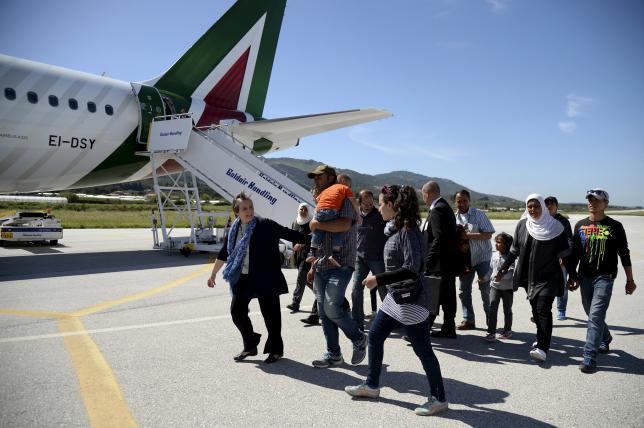 A group of Syrian refugees arrive to board a plane with Pope Francis at the airport of Mytilene, in the Greek island of Lesbos, April 16, 2016. REUTERS/Filippo Monteforte/Pool