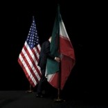 A staff member removes the Iranian flag from the stage during the Iran nuclear talks in Vienna, Austria July 14, 2015. REUTERS/Carlos Barria