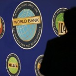 A man is silhouetted against the logo of the World Bank at the main venue for the International Monetary Fund (IMF) and World Bank annual meeting in Tokyo October 10, 2012.  REUTERS/Kim Kyung-Hoon
