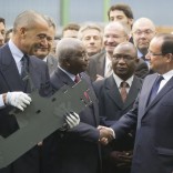 Mozambique's President Armando Guebuza, center, shakes hands with France's President Francois Hollande, right, as the head of CMN (Construction Mecanique de Normandie) Iskandar Safa holds a metal cutout of a fisher boat, at the CMN shipyard in Cherbourg, northwestern France, Monday, Sept. 30, 2013. French President Francois Hollande is vaunting a 200 million euro ship contract from Mozambique as a model for France's industrial renewal, and as salvation for Cherbourg's ship-building industry. (AP Photo/Michel Euler)