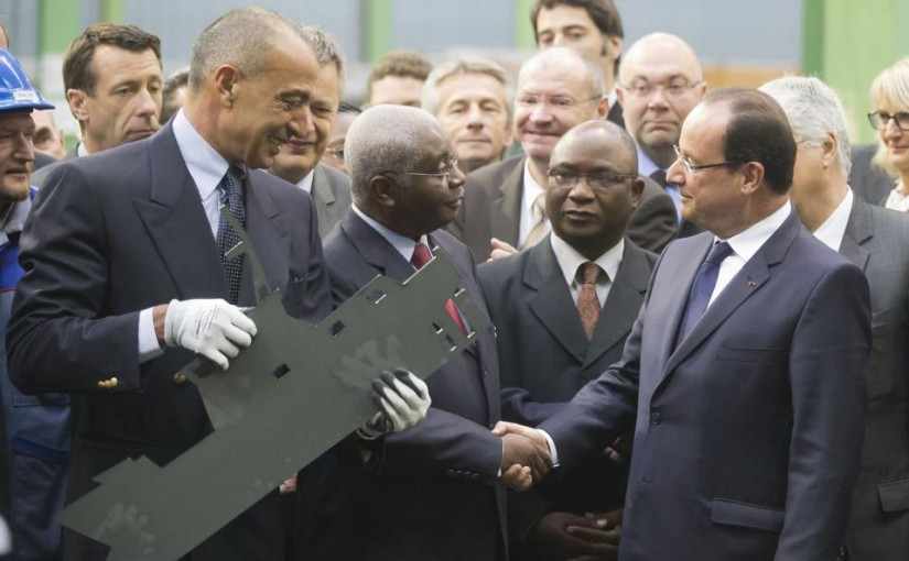 Mozambique's President Armando Guebuza, center, shakes hands with France's President Francois Hollande, right, as the head of CMN (Construction Mecanique de Normandie) Iskandar Safa holds a metal cutout of a fisher boat, at the CMN shipyard in Cherbourg, northwestern France, Monday, Sept. 30, 2013. French President Francois Hollande is vaunting a 200 million euro ship contract from Mozambique as a model for France's industrial renewal, and as salvation for Cherbourg's ship-building industry. (AP Photo/Michel Euler)