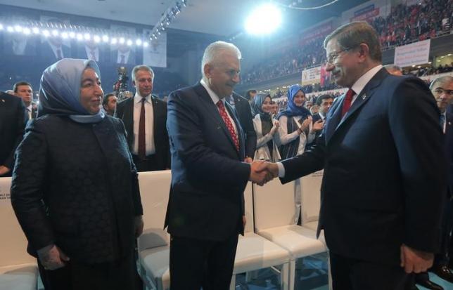 Transportation Minister Binali Yildirim (C), accompanied by his wife Semiha Yildirim (L), shakes hands with Turkey's outgoing Prime Minister Ahmet Davutoglu during the Extraordinary Congress of the ruling AK Party (AKP) to choose the new leader of the party, in Ankara, Turkey May 22, 2016. REUTERS/Riza Ozel/Pool