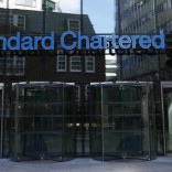 A man walks past the head office of Standard Chartered bank in the City of London February 27, 2015. I REUTERS/Eddie Keogh