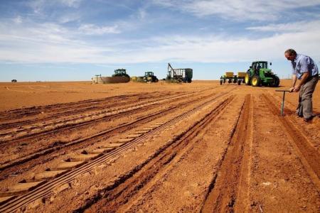 A farmer inspects the soil ahead of planting at a maize field in Wesselsbron, a small maize farming town in the Free State province of South Africa, January 13, 2016. REUTERS/Siphiwe Sibeko/File Photo