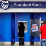 Customers queue to draw money from an ATM outside a branch of South Africa's Standard Bank in Cape Town, March 15, 2016. REUTERS/Mike Hutchings