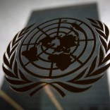 The United Nations headquarters building is pictured though a window with the UN logo in the foreground in the Manhattan borough of New York August 15, 2014.    REUTERS/Carlo Allegri