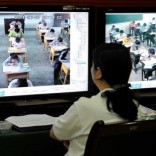A staff from the city's command centre of education exams watches real time monitors showing students taking the National College Entrance Exams in Chongqing municipality, June 7, 2011.  REUTERS/Stringer