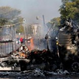 Locals walk past a shell of a burnt out truck used to barricade roads by protesters in Atteridgeville a township located to the west of Pretoria, South Africa June 21, 2016. REUTERS/Siphiwe Sibeko