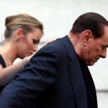 Former Italian Prime Minister Silvio Berlusconi leaves the stage flanked by his girlfriend Francesca Pascale at the end of a rally to protest his tax fraud conviction, outside his palace in central Rome, Italy August 4, 2013. REUTERS/Alessandro Bianchi/