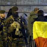 Belgian soldiers patrol as people pay tribute to the victims of Tuesday's bomb attacks at the Place de la Bourse in Brussels, Belgium, March 26, 2016.  REUTERS/Francois Lenoir