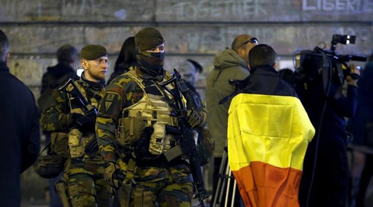 Belgian soldiers patrol as people pay tribute to the victims of Tuesday's bomb attacks at the Place de la Bourse in Brussels, Belgium, March 26, 2016.  REUTERS/Francois Lenoir