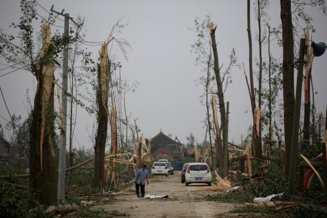 A villager walks on a damaged road after a tornado hit Funing on Thursday, in Yancheng, Jiangsu province, June 24, 2016. REUTERS/Aly Song