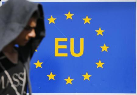 A migrant walks next to an EU sign at the border with Serbia in Tovarnik, Croatia September 17, 2015. REUTERS/Antonio Bronic