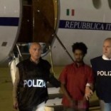 Medhanie Yehdego Mered (C), 35, is pictured with Italian policemen as they land at Palermo airport, Italy, following his arrest in Khartoum, Sudan, on May 24. Picture released on June 8, 2016 by Italian Police Department. Image pixellated at source. Italian Police Department/Handout via REUTERS