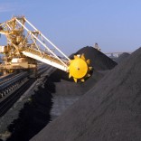 A bucketwheel reclaimer rides on rails between huge coal stockpiles at the Port Waratah coal loading facility in Newcastle, Australia Tuesday, June 1, 2004. Australian exports rose to the second highest on record in October, narrowing the trade deficit more than expected, as miners including Portman Ltd. and BHP Billiton earned more from commodity shipments to China. Photographer: Gillianne Tedder/Bloomberg News