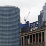 The logo of VTB Bank is displayed on the roof of a building, with towers of the Moscow International Business Center, also known as "Moskva-City", seen in the background, in Moscow March 18, 2013. REUTERS/Sergei Karpukhin