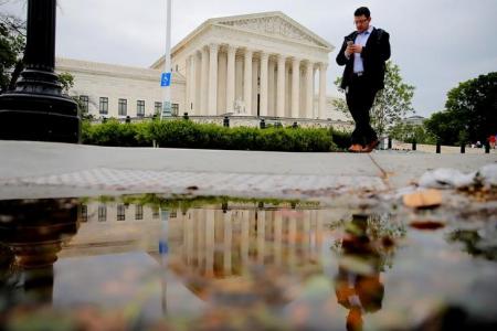 A pedestrian walks in front of the U.S. Supreme Court building in Washington, U.S., May 19, 2016.  REUTERS/Carlos Barria