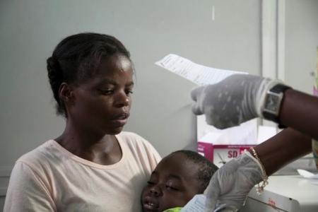 A mother holds her son suffering from yellow fever as she waits for a prescription at a hospital in Luanda, Angola, March 15, 2016.  REUTERS/Herculano Coroado