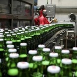 Technicians inspect beer bottles on a conveyor belt at a brewery in Gisneyi, western Rwanda,  file.  REUTERS/Hereward Holland
