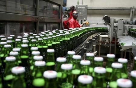 Technicians inspect beer bottles on a conveyor belt at a brewery in Gisneyi, western Rwanda,  file.  REUTERS/Hereward Holland