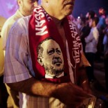 A supporter wears a scarf depicting Turkish President Tayyip Erdogan during a pro-government demonstration at Taksim square in Istanbul, Turkey, July 19, 2016. Picture taken July 19, 2016.  REUTERS/Alkis Konstantinidis