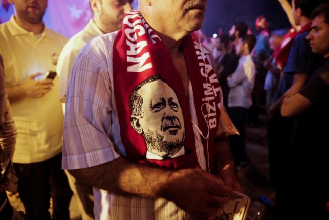 A supporter wears a scarf depicting Turkish President Tayyip Erdogan during a pro-government demonstration at Taksim square in Istanbul, Turkey, July 19, 2016. Picture taken July 19, 2016.  REUTERS/Alkis Konstantinidis