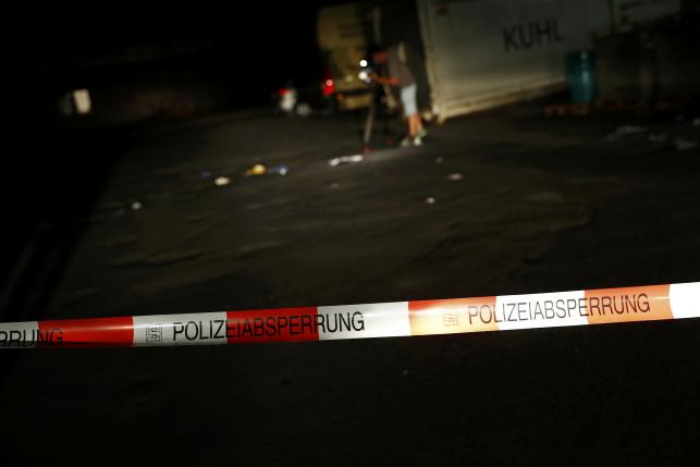 A cameraman films at the scene where a man was shot dead by the police after attacking passengers on a train with an axe near the city of Wuerzburg, Germany July 19, 2016.  REUTERS/Kai Pfaffenbach