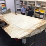 Australian and Malaysian officials examine aircraft debris at the Australian Transport Safety Bureau headquarters in Canberra, Australia, July 20, 2016 after it was found on Pemba Island, located near Tanzania, in late June and was transported to Australia for examination. Australian Transport Safety Bureau/Handout via REUTERS