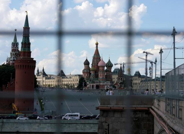 A view through a construction fence shows the Kremlin towers and St. Basil's Cathedral on a hot summer day in central Moscow, Russia, July 1, 2016.  REUTERS/Maxim Zmeyev/File Photo