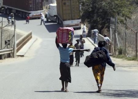 Women carry their belongings as they cross the border between Mozambique and Zimbabwe September 18, 2010.  REUTERS/Goran Tomasevic