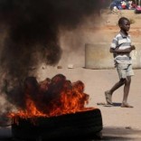 A boy walks past a burning tyre in Mufakose in Harare, Zimbabwe, July 6, 2016. REUTERS/Philimon Bulawayo