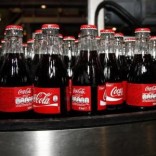 Bottles of Coca-Cola are seen on the production line at their bottling plant in Clamart near Paris June 10, 2010.   REUTERS/Jacky Naegelen
