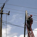 Power officials stand on ladders to fix electric cables along a road in Egbeda dstrict in Nigeria's commercial capital Lagos, July 1, 2015. Picture taken July 1, 2015. REUTERS/Akintunde Akinleye
