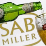 Photo illustration of beer flowing from a bottle of Stella Artois into a glass, part of the Anheuser-Busch InBev group, seen against a SABMiller logo, November 5, 2015.   REUTERS/Dado Ruvic/Illustration/File Photo